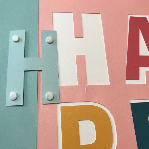 Use the 3D foam dots on happy for some depth on your Cricut scrapbook template 